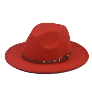 Detail of red wool felt hat featuring brown leather band and gold buckle accents