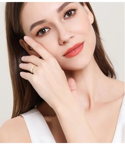 Close-up of a slim gold moissanite ring with a rectangular baguette cut stone on finger