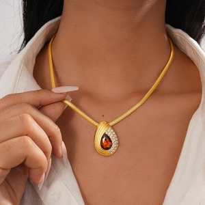 Detail of vintage snake chain necklace with teardrop red gemstone and crystal pave