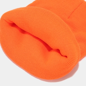 Nahaufnahme der leuchtend orangefarbenen Strickmütze mit feiner Textur und Umschlag