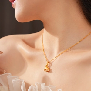 Close-up of gold-plated unicorn pendant with small crystals on a layered necklace chain