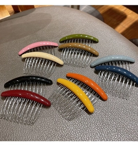 Detailed view of ten colorful seamless hair side combs with metal teeth on leather