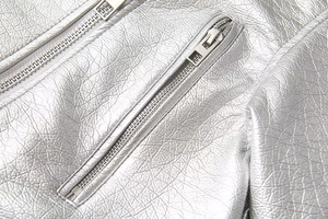 Macro view of silver metallic leather jacket with high-quality metal zipper details