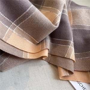 Close-up of gray and beige plaid pattern showing high-quality wool-like texture