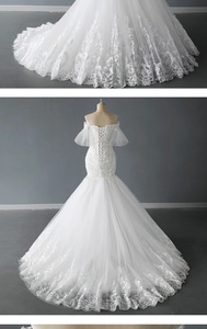Detail of white off-shoulder lace wedding dress with mermaid cut and sequined long train