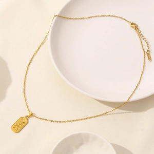 18K gold plated stainless steel necklace featuring a celestial sun and moon pendant on a plate