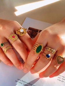 Detail of vintage bohemian gold rings set with colorful stones on model fingers