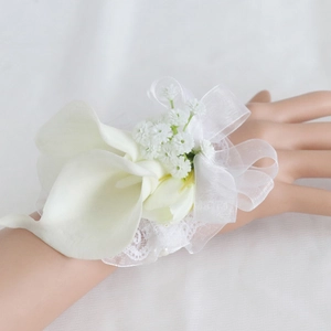 Elegant white calla lily wedding wrist corsage with lace and organza ribbon on model