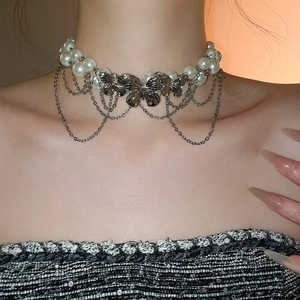 Detail of double-layer pearl necklace with silver butterflies and cascading tassels