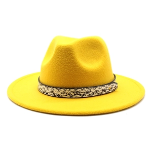 Detail of yellow wool fedora hat featuring a stylish snakeskin band and gold metal buckle