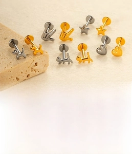 Detail of titanium alloy studs with heart and star shapes in silver and gold finishes