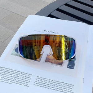 Close-up of white semi-rimless cycling sunglasses with colorful polarized lenses on a magazine