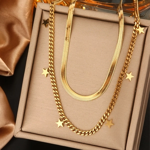 Détail d'un collier étoilé double rang plaqué or 18 carats sur fond de soie dorée