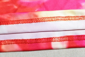 Detailed stitching on pink and orange tie-dye stretchy knit dress with flatlock seams