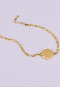 Detailed view of an 18K gold-plated Figaro chain bracelet with a smooth round pendant