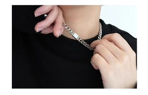 Close-up of a model wearing a silver titanium steel Cuban link necklace with square clasp