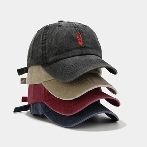 Stacked washed cotton baseball caps in charcoal, khaki, burgundy, and navy colors