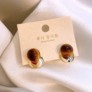 French vintage tiger eye stone round earrings with gold base on a textured display card