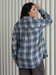 Detail view of the back tailoring and blue-grey plaid pattern on the loose-fit shirt