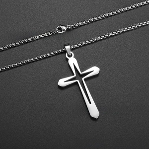 Detailed close-up of hollowed-out stainless steel cross pendant on a silver box chain