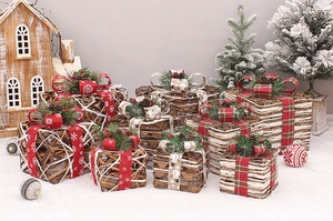 Detail of rattan Christmas gift boxes with pine cones, berries and festive ribbons