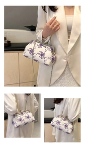 Detail showing vintage lace floral embroidery and silver metal clasp on the cream handbag
