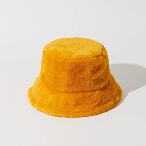 Macro shot of the soft yellow faux rabbit fur texture on a warm bucket hat