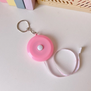 Pink retractable soft measuring tape with key ring showing clear metric and inch scales