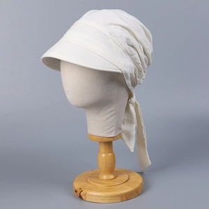 Detail of off-white cotton turban sun hat with adjustable back ribbons and pleated fabric