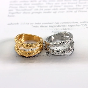 Detailaufnahme goldener und silberner Ringe mit Hammerschlag-Textur auf Buchseiten