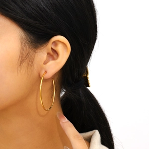 Minimalist 18K gold plated stainless steel oversized hoop earrings worn by a model
