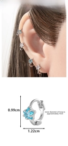 Detailed view of tiny blue star zircon earrings showing 0.99cm height measurements