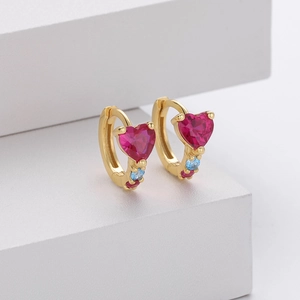 Detail of gold heart earrings with pink ruby zircon and blue crystal accents
