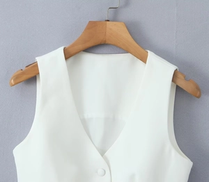 Close-up of white sleeveless V-neck vest featuring fine stitching and tonal buttons