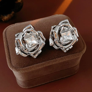 Vue macro de boucles d'oreilles rose en argent avec zircon sur velours brun