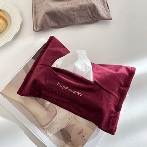Close-up of luxury burgundy velvet tissue bag with golden Happiness embroidery detail