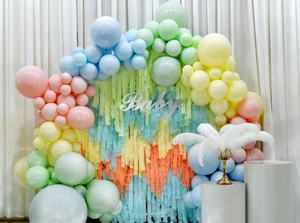 Pastel balloon arch and colorful crepe paper streamers with silver Baby sign for party decor