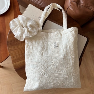 Detailed embroidery texture on white lace tote bag with matching large hair scrunchie set