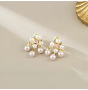 Detail of French vintage gold pearl earrings with pink gemstones and dangling beads