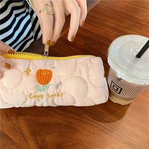 Detailed shot of pink quilted pencil case with tulip embroidery and yellow zipper