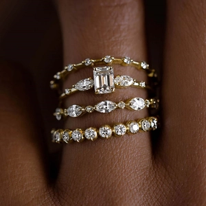 Elegant 4-piece set of stackable gold-tone rings featuring emerald cut and marquise zirconia