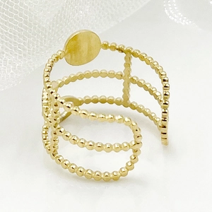 Detailed close-up of golden multi-layered open ring with delicate beaded metal accents