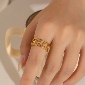 Close-up of a 18k gold-plated openwork heart ring worn on a finger for fashion