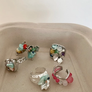 Bohemian silver rings set with colorful beads and floral details in a cream tray