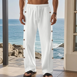Detail of white linen trousers with drawstring waist and brown wood buttons on the side