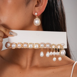 Detailed close-up of vintage pearl earring set with gold accents and baroque designs
