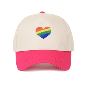 Vista frontale di un cappellino beige e rosa a 5 pannelli con cuore ricamato arcobaleno.