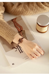 Detail of square vintage chain watch worn on wrist with elegant lifestyle props