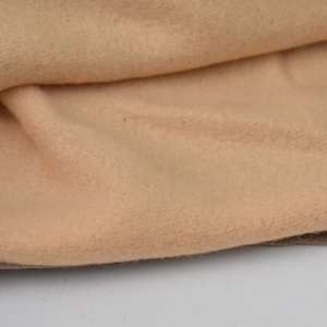 Close-up of soft and dense fleece fabric texture in beige for autumn winter hats