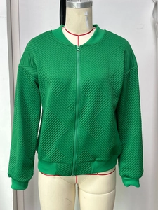 Detail of green long-sleeved jacket featuring diamond embossed texture and zipper closure